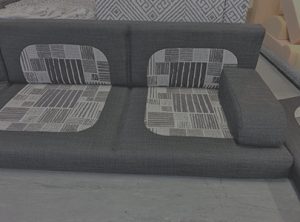 Motorhome corner seating unit in factory trimmed in charcoal with grey and white pattern in centre of squab