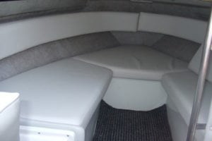 Finished marine interior after refurbishment with newly upholstered white and grey seating area