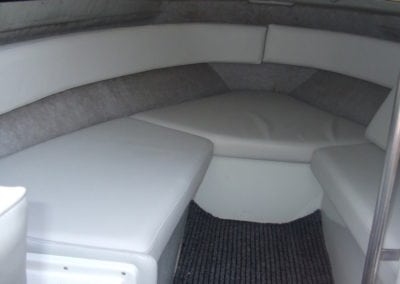 Finished marine interior after refurbishment with newly upholstered white and grey seating area