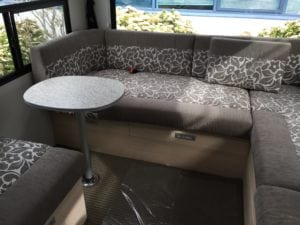 Motorhome interior seating area upholstered in brown and white floral pattern with solid brown accent