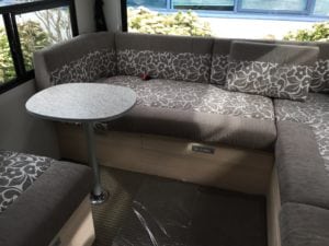 Motorhome interior seating area upholstered in brown and white floral pattern with solid brown accent