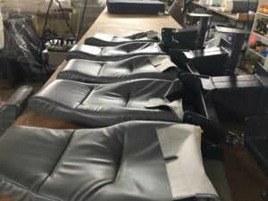 Row of 5 seat backs being assembled on workbench