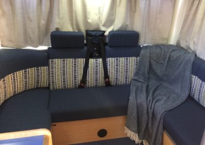 Motorhome seating area trimmed in navy with grey, white and green patterned accent