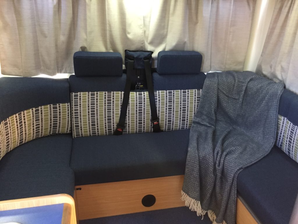 Motorhome seating area trimmed in navy with grey, white and green patterned accent