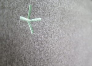 Mint coloured embroidered cross detailing on grey base colour fabric