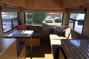 Brown cushioned seating area of motorhome before refurbishment
