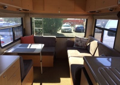 Brown cushioned seating area of motorhome before refurbishment