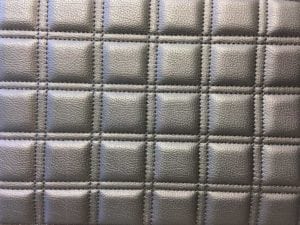 Starfish Products: Charcoal leather upholstery sewn in a square grid pattern