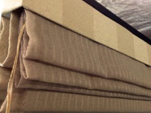 Roman blind close up, beige coloured, in drawn up position