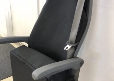 Side view of minivan seat in folded position after refurbishment. Retrimmed in black