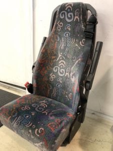 Front view of minivan seat in patterned fabric before refurbishment