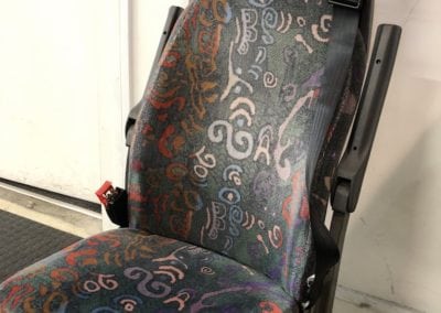 Front view of minivan seat in patterned fabric before refurbishment