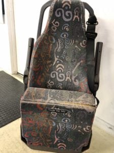 Front view of minivan seat in folded position. Patterned fabric before refurbishment