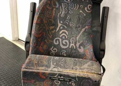 Front view of minivan seat in folded position. Patterned fabric before refurbishment