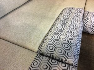 Motorhome corner seating in factory, upholstered in beige base colour with black and grey geometric patterned accent