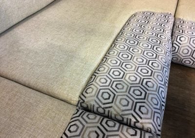 Motorhome corner seating in factory, upholstered in beige base colour with black and grey geometric patterned accent