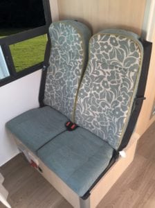 Motorhome second row seating in light blue and floral fabric with 3 point seat belts