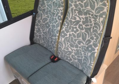 Motorhome second row seating in light blue and floral fabric with 3 point seat belts