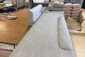 Upholstery workbench with large cushion in foreground and smaller finished cushions in background