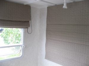 Two roman blinds installed in motorhome. Beige coloured. Left blind in open position, right blind in closed position.