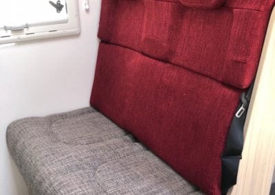 Passenger seating in motorhome trimmed in beige seat with red seat back