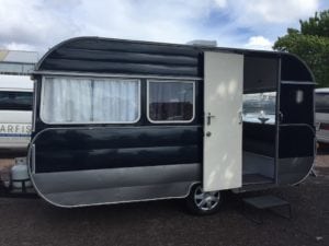 Black and silver caravan with the door open