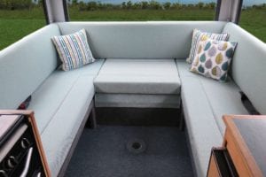 Motorhome interior cushions trimmed in a soft green. Bright throw cushions sit in each corner.