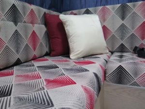 Cushions trimmed with a fabric in a black, white and red geometric pattern