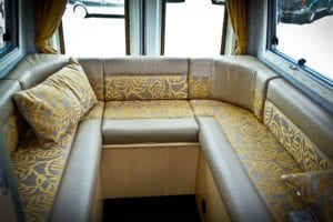 Motorhome lounge two tone cushions with gold leaf pattern and plain fabric edges in brown shade