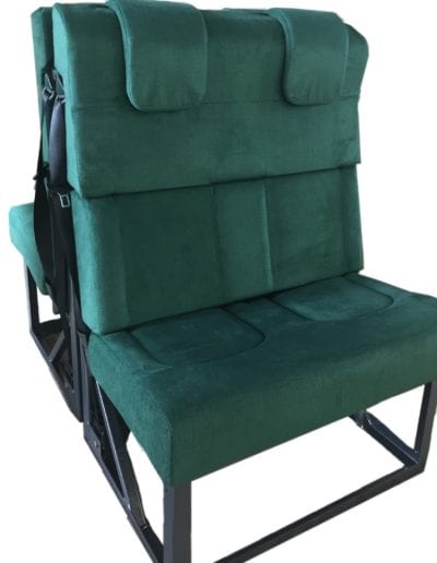 Second row two seater upholstered in green fabric. Rear facing seat backs onto front facing seat.
