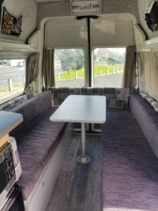 2 berth walk through motorhome lounge upholstered in chocolate brown fabric with a geometric accent used for the side cushions