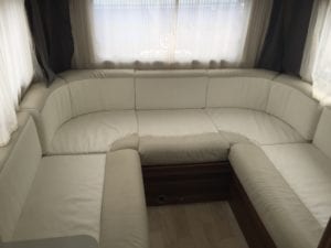 Before refurbishment 6 berth motorhome lounge with baggy, wrinkled beige and cream cushions