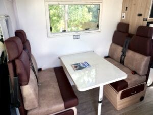 Dinette seating in brown and burgundy with white table with magazine