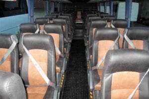 Dark brown and caramel two tone bus seats in coach with aisle.